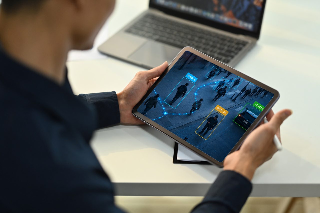 Visiontech team member reviewing FACES2 AI detection of people, weapons, and vehicles on a tablet